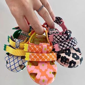 Slipper Sandal Anak Laki Laki Perempuan Musim Panas Melissa Baotou Sandal Berongga Pola Warna Warni Sepatu Pantai Kanvas Kancing Lucu Dicetak Jelly 230510