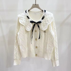 Top coreano in lana lavorata a maglia jacquard con testa di torsione e ricamo con alfabeto da donna di design con fiocco rotondo