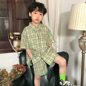 Completi di abbigliamento Set di camicie coreane per ragazzi estivi Set di camicie monopetto a maniche corte a quadretti verde casual da ragazzo di moda + pantaloncini Set di 2 pezzi Z230717