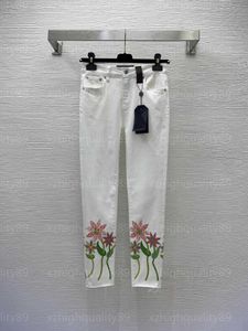 Dżinsowe dżinsowe dżinsowe projektanci białych spodni Projektantki Spodnie Wysokiej jakości odzież kwiatowy nadruk surowy krawędź uprawa spustowa noga wysoka rozciąganie dziewięć punktów Jean damska 55