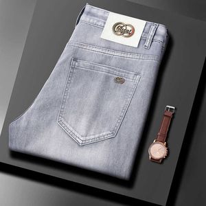 Märke europeiska jeans män elastiska smala passformar små fötter sommar tunna klädljus lyxiga fashionabla casual byxor