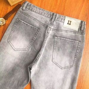 Jeans de grife Jeans com monograma incrustado de diamantes para homens e mulheres com botões metálicos embelezados com jeans masculinos com monograma estampado