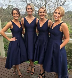 Vestido de dama de honor alto y bajo con bolsillos Una línea de longitud de té Satén azul marino oscuro Vestidos de invitados de boda simples Frente corto con cuello en V Sin mangas Vestidos de fiesta de graduación para mujeres Niñas