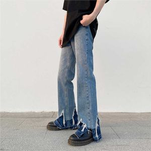 Мужские джинсы Новые модные мужские джинсы на высокой улице Сторона расщепляет необработанные мужские швабры.