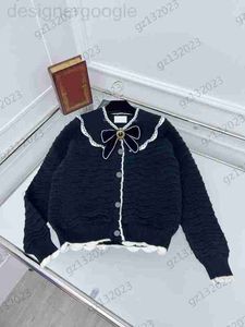 Damskie swetry projektantka damska łuk broszka dekoracyjna Odłączona klapa z dzianiny falisty guzik w paski otwarte długie rękawy luksus dzianinowy