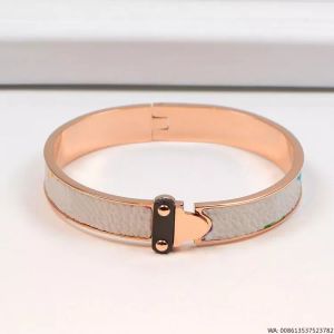 Nuovo bracciale rigido di lusso Designer di gioielli Bracciale in pelle da donna con chiusura a cuore Braccialetti con ciondoli Hardware Modello a quattro foglie Fiore Borsa in oro Pendente Moda appesa