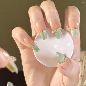 Unghie finte artificiali indossate a mano Mostra cannella bianca latte catena di diamanti verdi potenziamento delle unghie staccabile e di lunga durata