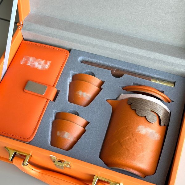 Designer-Teeset in Orange mit klassischem Buchstaben-Logo, Teezubereitungsset für unterwegs, praktisches Geschenk-Teeset inklusive Notizbuch und tragbarem Koffer