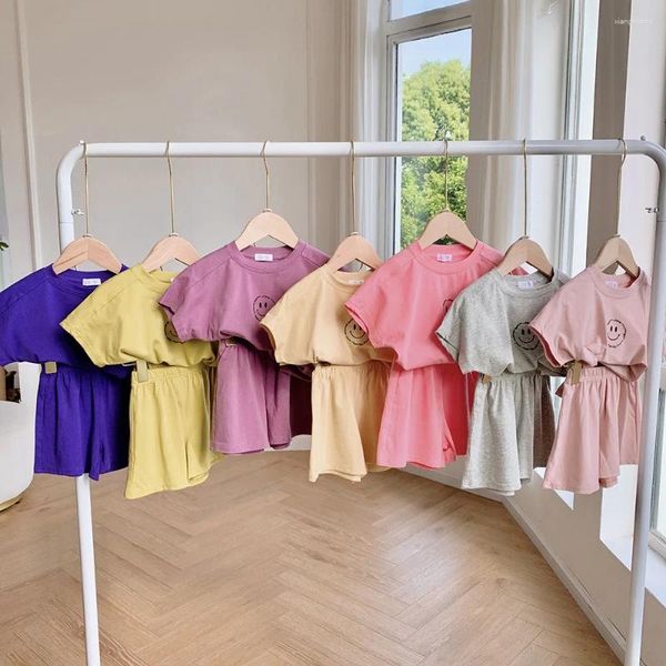 Set di abbigliamento 2024 Set di vestiti estivi per ragazze del bambino Set di pantaloncini in vita elastica allentata in cotone solido Completo di camicie con sorriso stampato Abiti da neonato