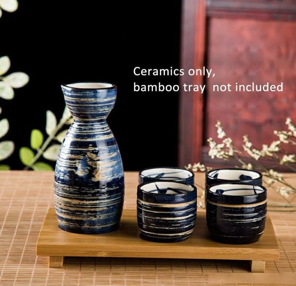 Традиционные японские саке с элегантной керамической винной бутылкой и чашками азиатских винных подарков устанавливают синий муссонный круг.