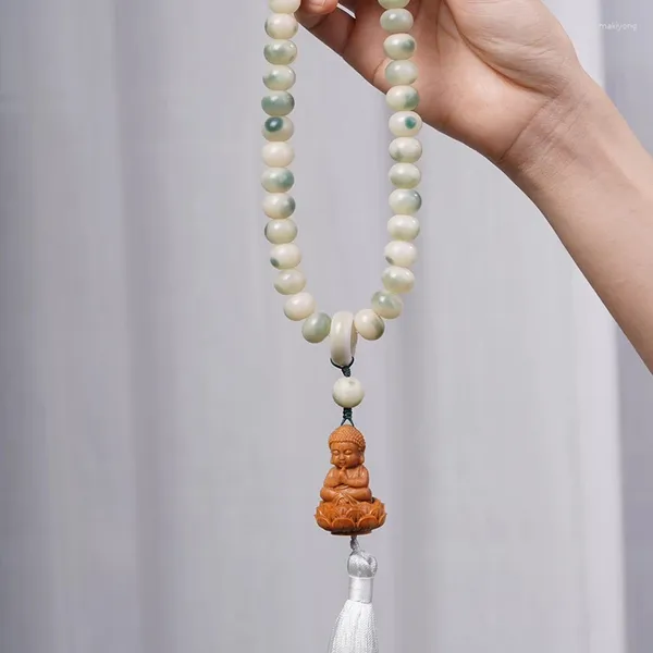 Strand Bodhi Bracelet enrolada em torno dos dedos raiz de flor macia, tocando contas de buda esculpida de madeira e