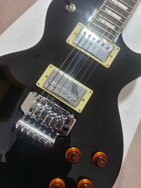 Corpo de guitarra preto, escala trapezoidal em jacarandá, hardware eletrônico de níquel-cromo, design ergonômico, tremolo Floyd rose, em estoque