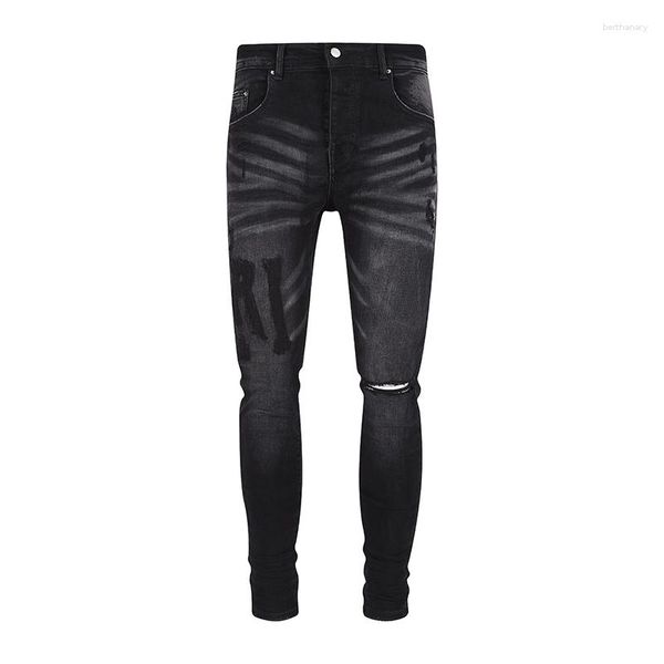 Jeans da uomo Arrivo AM Strappato High Street Black Knee Hole Piedi aderenti Lettere graffiate per uomo Pantaloni in denim elasticizzato
