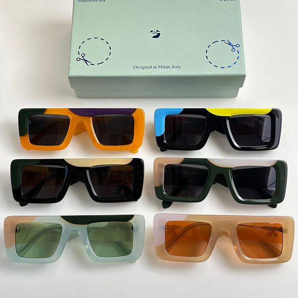 Дизайнерские солнцезащитные очки Черные солнцезащитные очки с белыми стрелками по бокам Разноцветная прямоугольная форма и темно-синие линзы Выгравированный логотип на линзах В оригинальной коробке