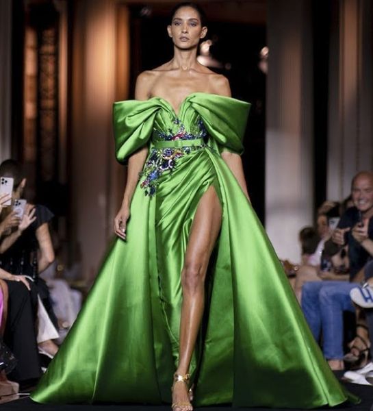 Vestindo um vestido de noite de cintura alta verde de cintura alta com lantejoulas coloridas no último lançamento da marca Zuhair Murad em 2023.