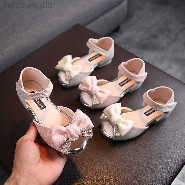 Sandálias 2022 São de verão Sandals Big Bow Girls Hollow Out Princess Sandals Novo estilo Fashion Kids Sof Sole Wedding Sapatos planos H04 W0327