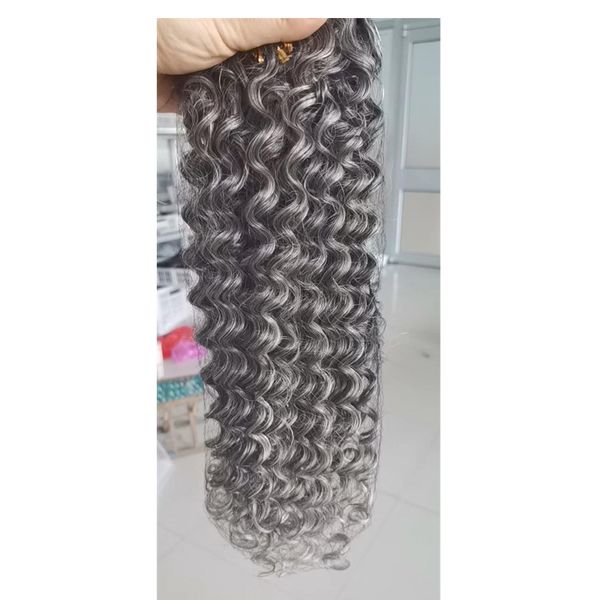 Короткие серо -серо -извращенные афро вьющиеся волосы пучки с плетением волос от от черного до серых соли и перца.
