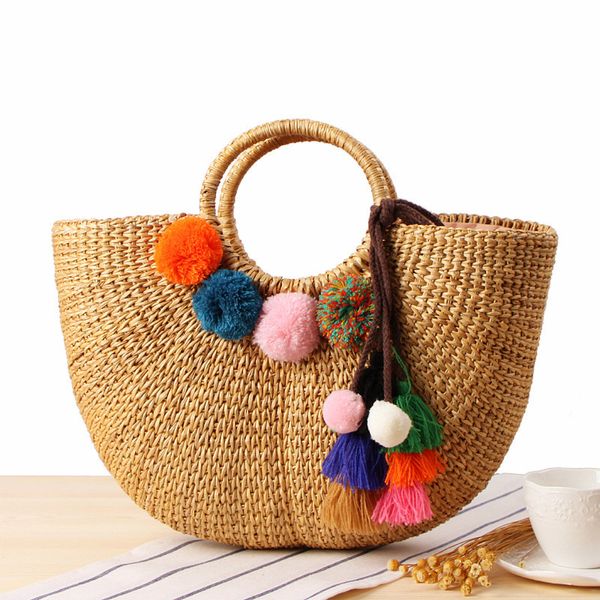 Handgetragene geflochtene Strohtasche handgefertigte gelbe Gras geflochtene weibliche Tasche bunte Quaste Wollball Strandtasche