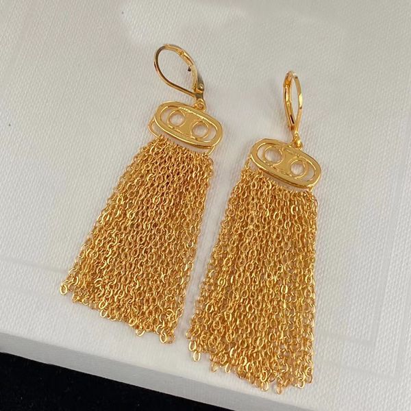 Absolutamente o último hit de brincos Dangle. Tástels em cascata banhados a ouro de 18k. Logotipo de latão claro e brilhante, designer de brinco de luxo para mulheres. Jóias de designer de Aretes