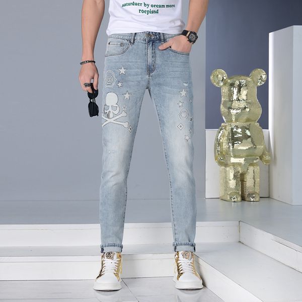 Jeans di marca alla moda da uomo Pantaloni di jeans azzurri stampati con teschio streetwear Pantaloni da uomo di tendenza coreani versatili slim piccoli piedi estivi 28-36