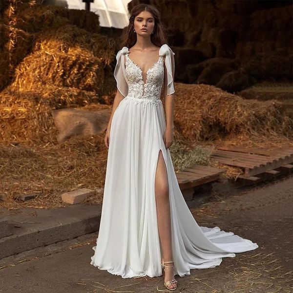 Abito da sposa Boho in chiffon con scollo a V con applicazioni in pizzo modesto. Abiti da sposa da spiaggia eleganti con spalline laterali senza maniche e fiocco