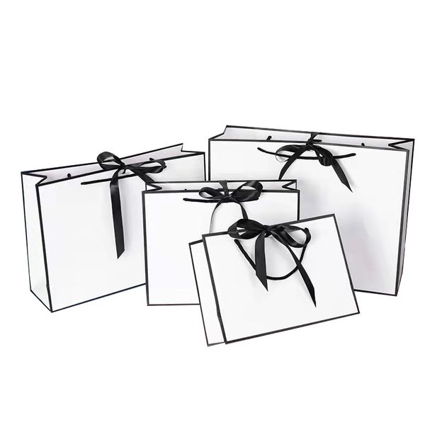 Kreatives Design, große weiße Kraftpapiertüte mit schwarzem Rand und Griff, Geschenktüte aus Papier mit Schleife für Hochzeiten
