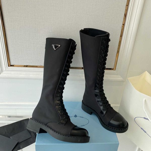 Hohe Kampfstiefel, schwarzer Kalbslederbesatz, Patchwork-Nylon, abgerundete Zehenpartie, flache Dreiecksplakette, luxuriöser Designer, kniehoch, Schnürung, Vamp-Seite für