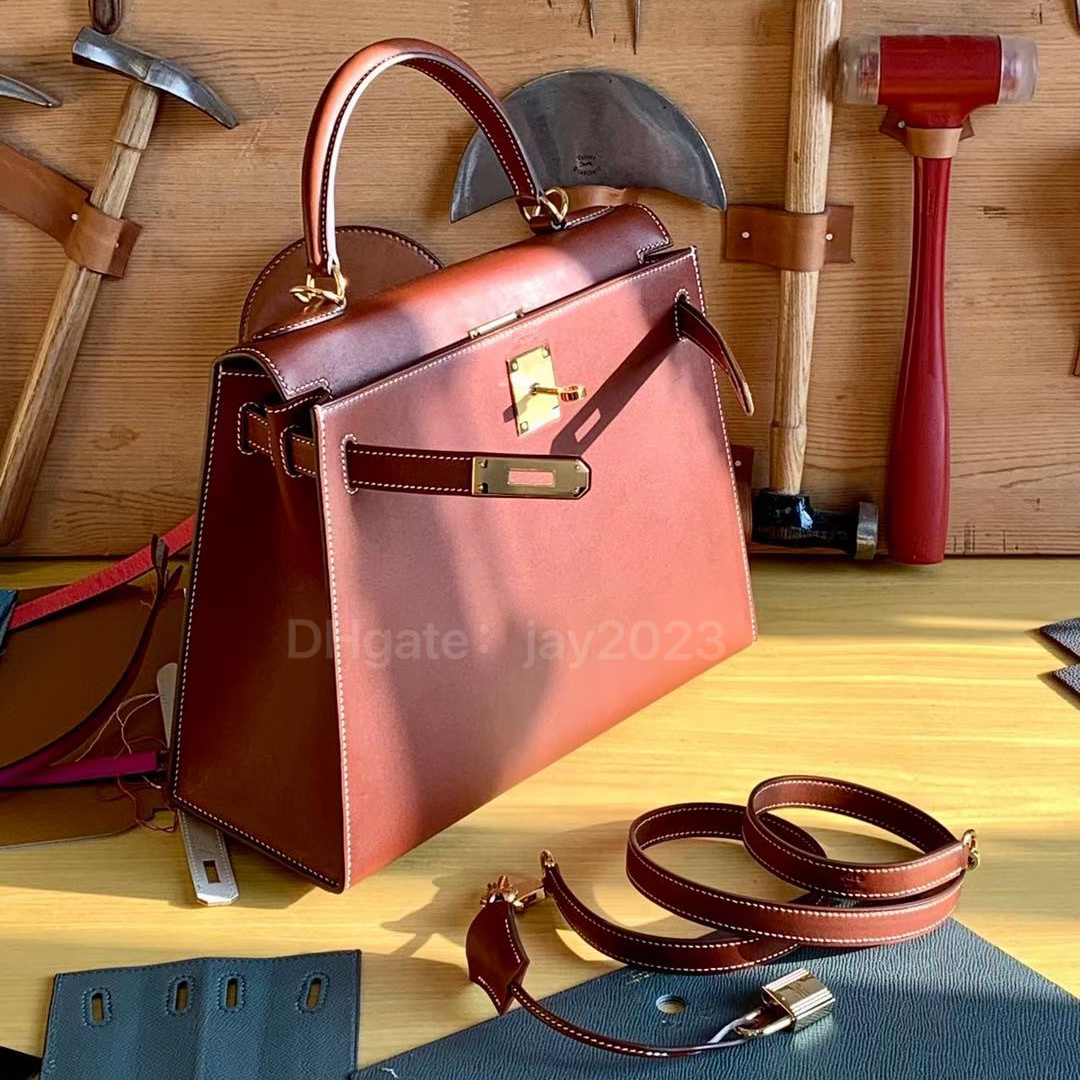 10s Helt handgjorda tygväska Designer Bag Classic Luxury Clamshell 28cm sadel läder röd brun guldspänne. Utsökt bivax trådhandsömning