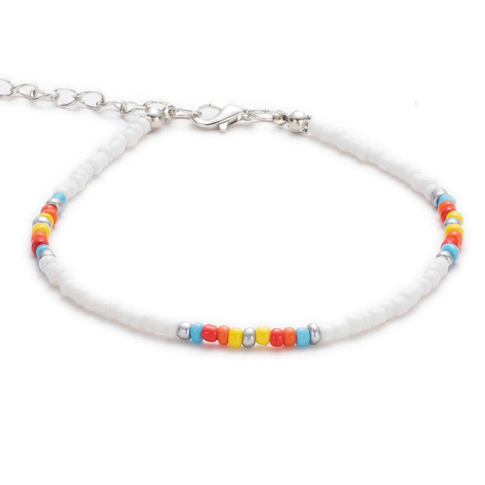 Bracciale alla caviglia intrecciato con perline di riso colorato, accessori i piedi della coppia di surf sulla spiaggia estiva