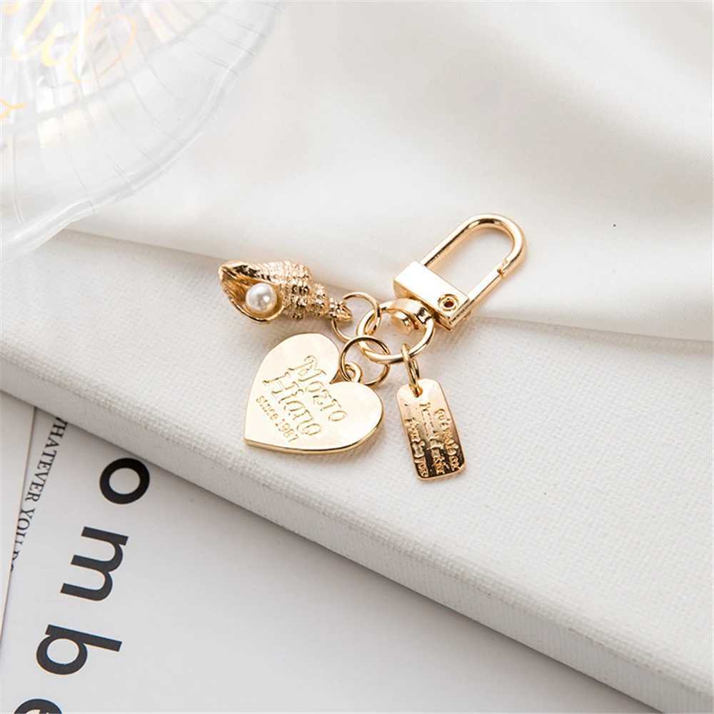 سلاسل المفاتيح Lanyards الفاخرة الاصطناعية اللؤلؤة المفتاحية المعدنية Peach Heart Pendant Keyring Women Fashion سماعة سماعة سحر حقيبة سحر المجوهرات ملحقات المجوهرات