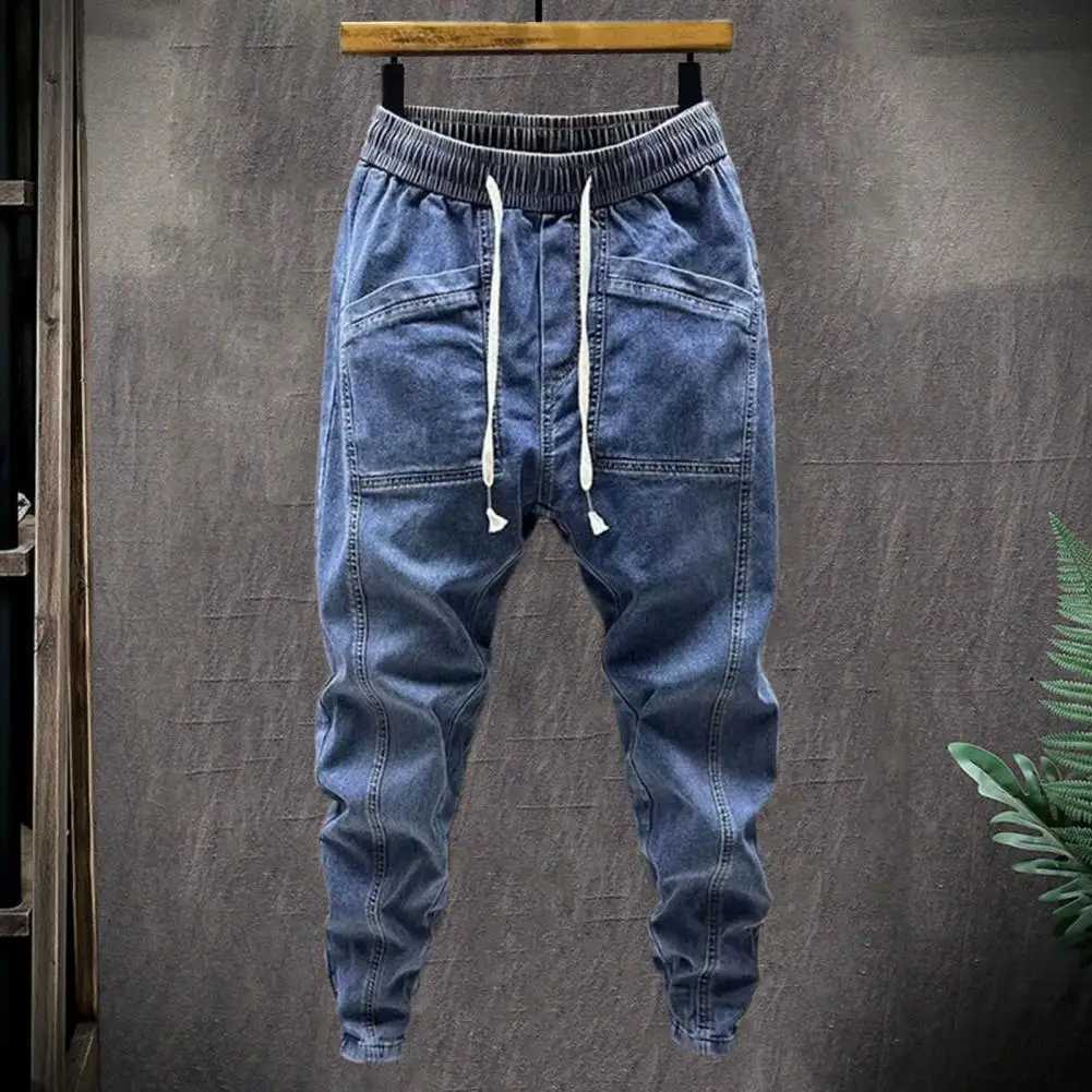 Mäns jeans Elastiska midja Jeans Mens elastiska dragkamp i midjan Denim Cargo Pants with Pockets Solid Color Harem Trousers för våren Autumn 240423