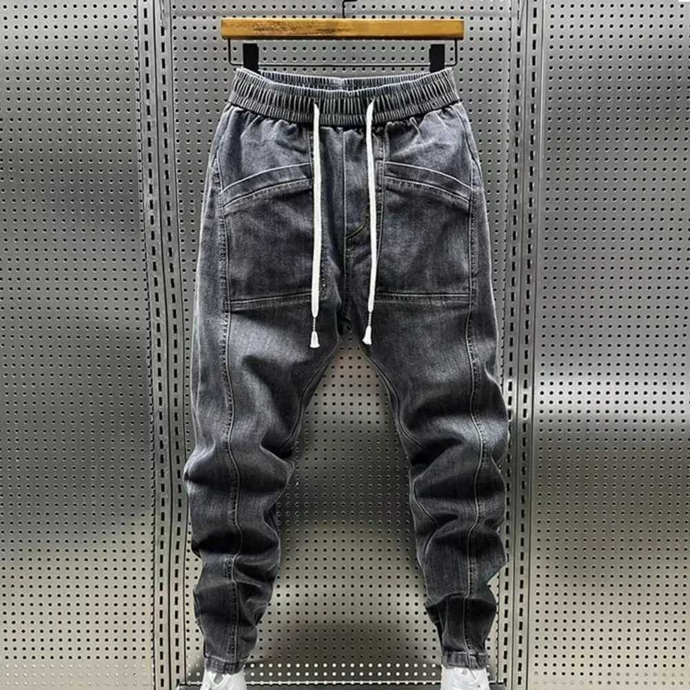 Mäns jeans Elastiska midja Jeans Mens elastiska dragkamp i midjan Denim Cargo Pants with Pockets Solid Color Harem Trousers för våren Autumn 240423