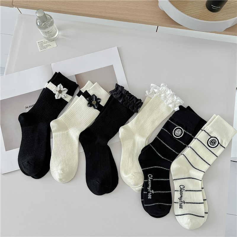 23 Automne et hiver Nouvelles chaussettes pour femmes Petites ornements de style parfum pour les chaussettes à tube en dentelle Black and White Stripe Doratives chaussettes décoratives