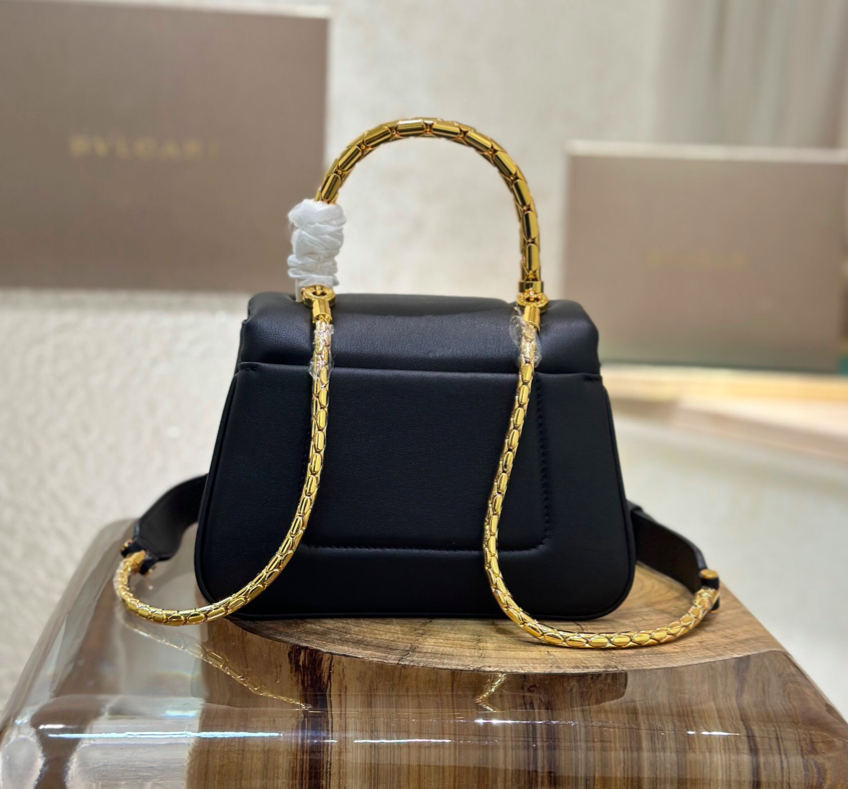 Este pequeño bolso tote encarna las características distintivas de la colección en un encantador diseño abullonado. Fabricada en piel de becerro acolchada, suave y duradera, de color negro.