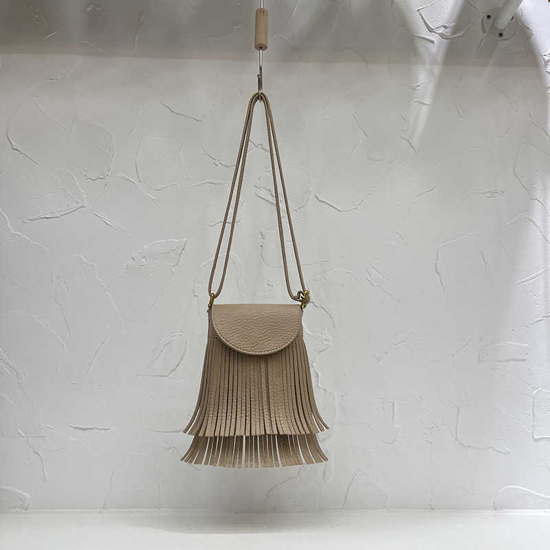 2022 Design Sense Koreansk mjukt läder Tofs Bucket Bag med Litchi-mönster Fashion Fried Street Mångsidig Skew Straddle Small Bag 230708