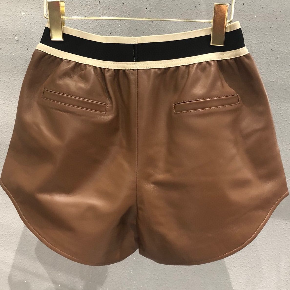 Shorts de couro PU com cintura elástica com estampa de logotipo feminino SML