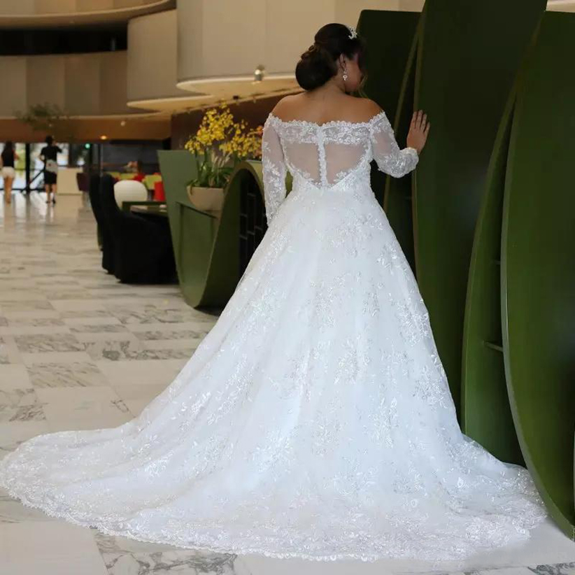 2023 Abiti da sposa taglie forti a maniche lunghe con spalle scoperte Appliques di paillettes luccicanti Pizzo Una linea Vedere attraverso la schiena Abiti da sposa Taglia personalizzata