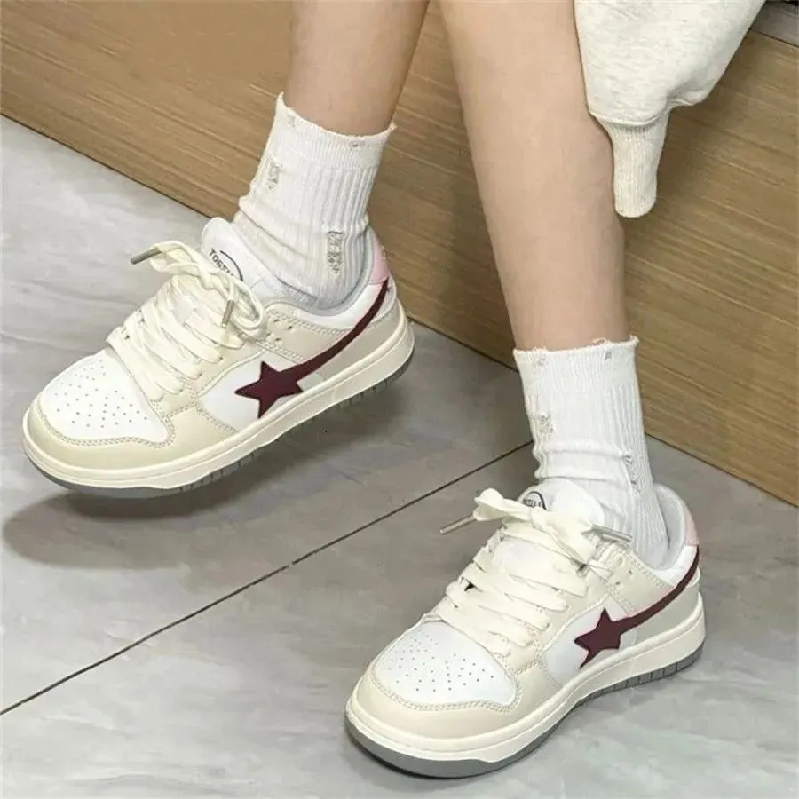 Damessneakers met vetersluiting in crèmewit en bordeauxrood, model Skate Star, een populaire retro studentensneaker met dikke zool, geschikt voor de herfst._voghion.com