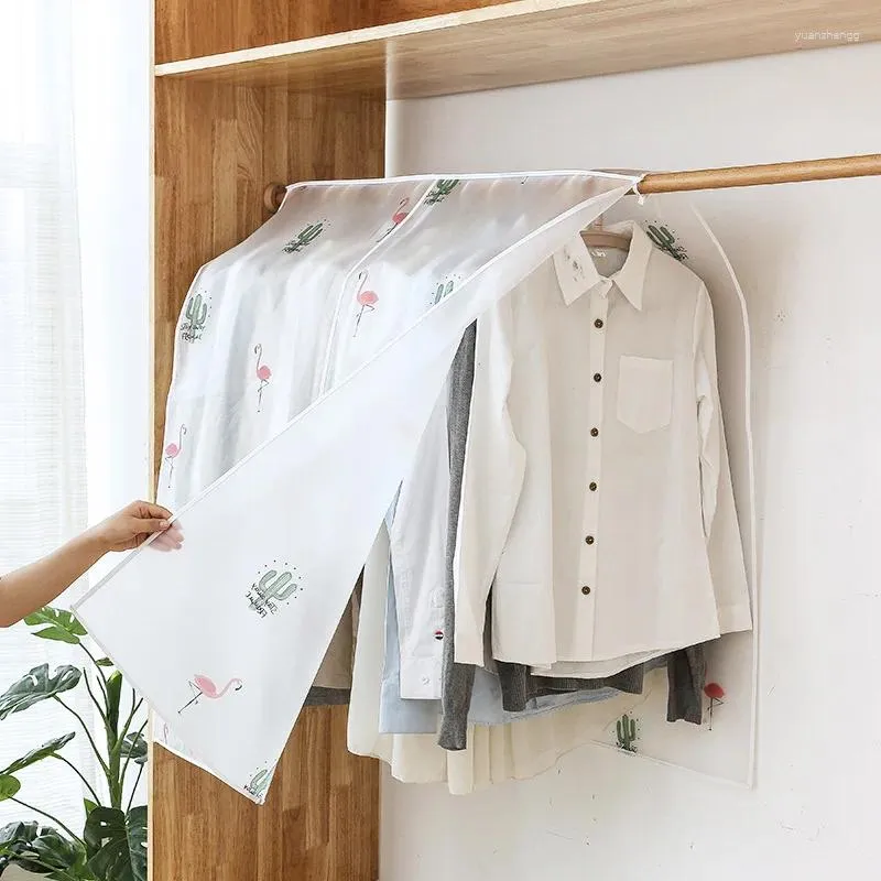 Boîtes de rangement cache-poussière pour les vêtements de la chambre suspendus à un cintre au sol pour les garder à l'épreuve de l'humidité.