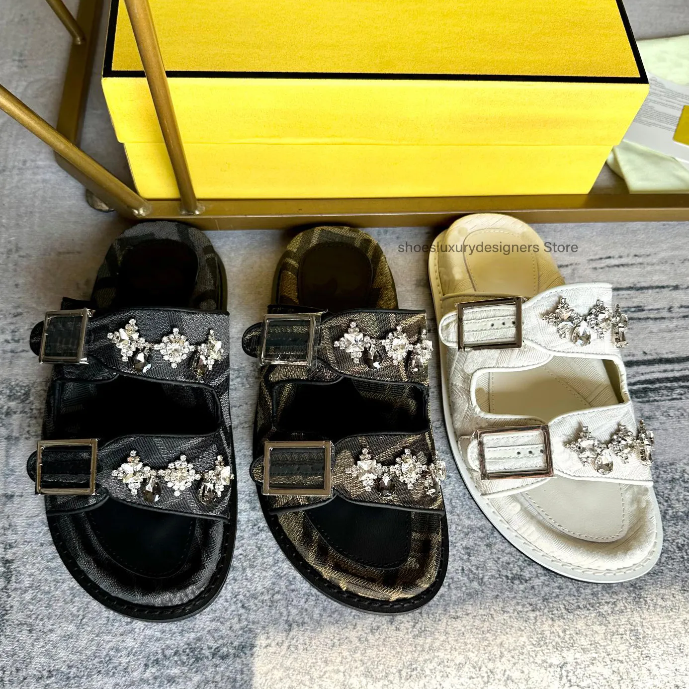 Offene Slip-on-Sandale mit runden Zehen und flacher Sohle, verziert mit zwei Schnallen und Strasssteinen. Sommerferien-Hausschuhe für Damen, Luxus-Designer für Fabrikschuhe mit Box