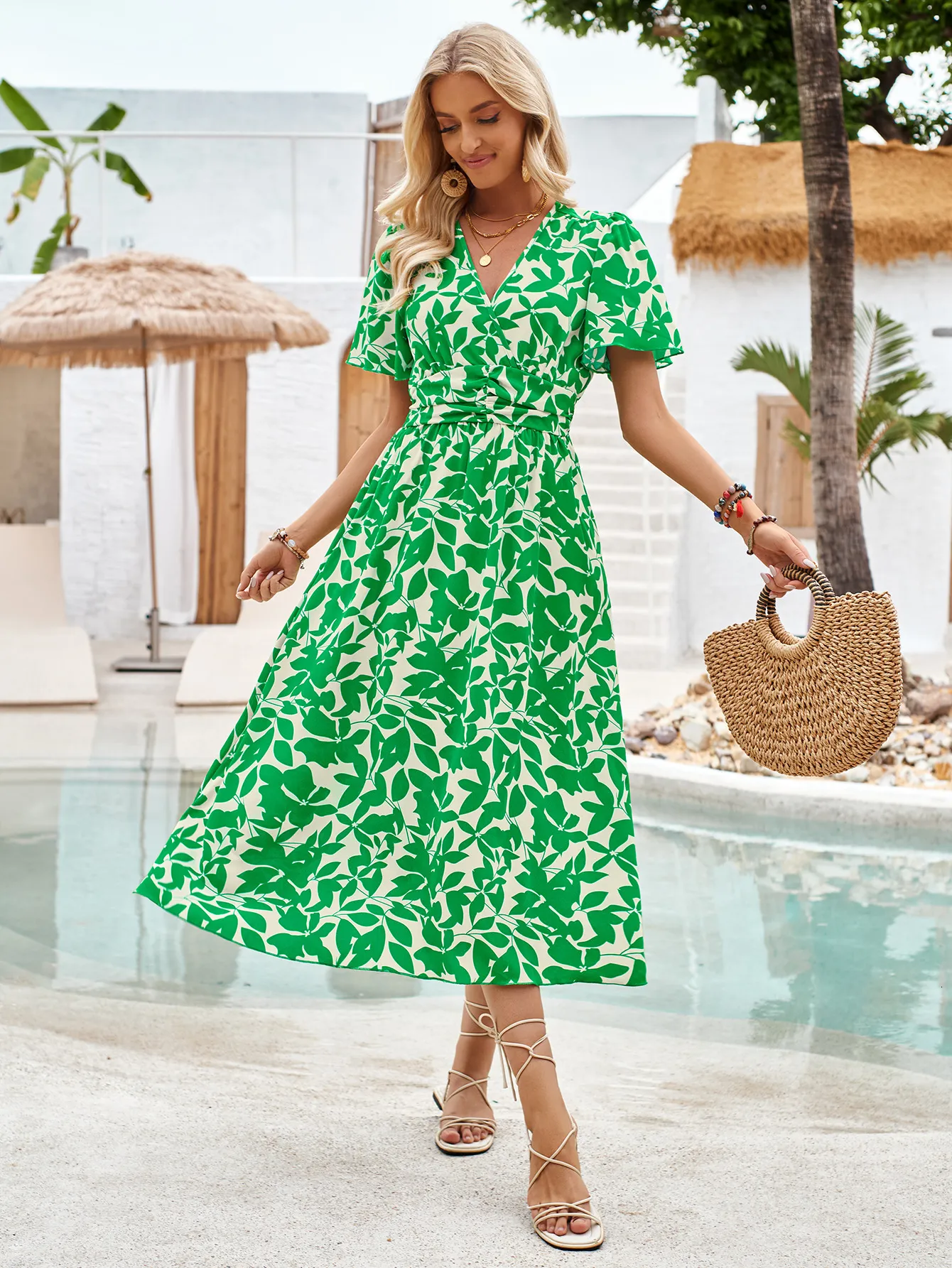 Floral green women's dress with short sleeves, styled with a straw bag and strappy sandals, perfect for summer.