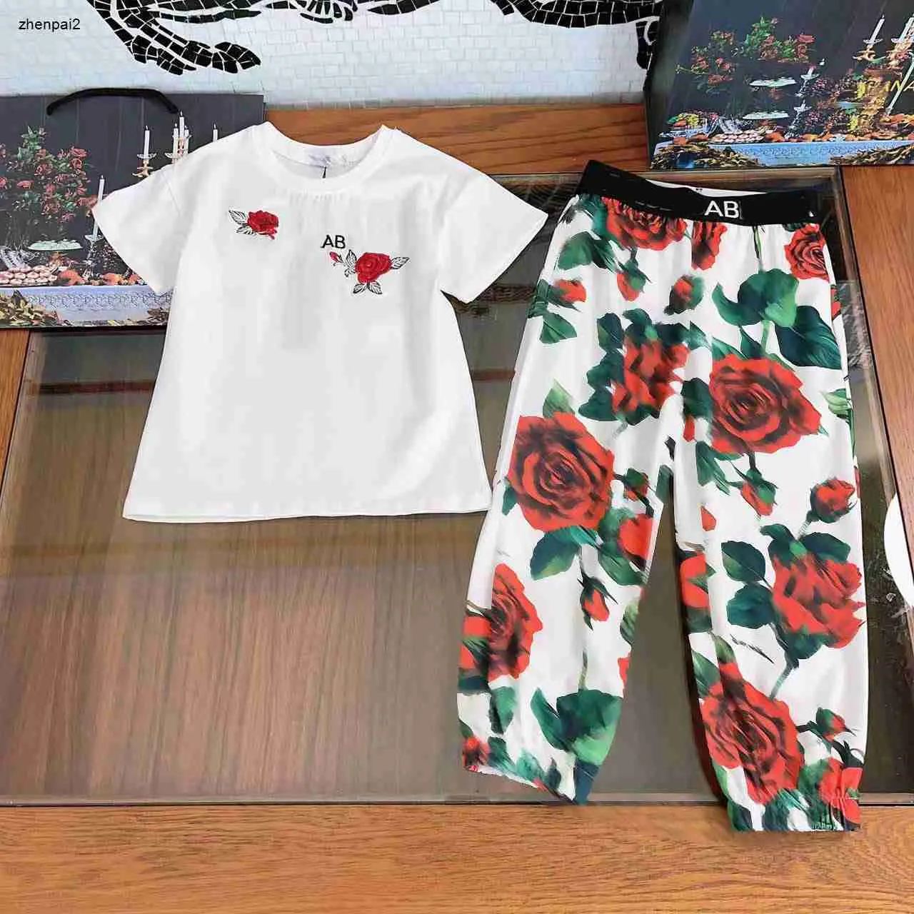 Luxuriöse Mädchen-Trainingsanzüge für Babys, zweiteiliges Set, Kinder-Designerkleidung, Größe 90–150 cm, T-Shirt mit roten Blumen und grünen Blättern und karierte Hosen, 24. März