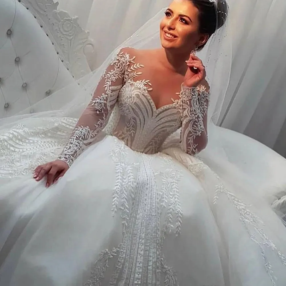 Abiti da sposa principessa Dubai maniche lunghe applicazioni di pizzo perle in rilievo avorio abiti da sposa linea a collo trasparente abito da sposa moderno arabo 2024