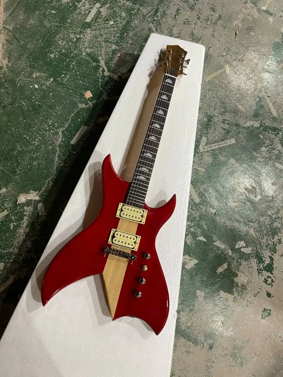 Guitare basse électrique à corps rouge de forme inhabituelle avec touche en palissandre, manche traversant le corps, matériel chromé, fournir un service personnalisé