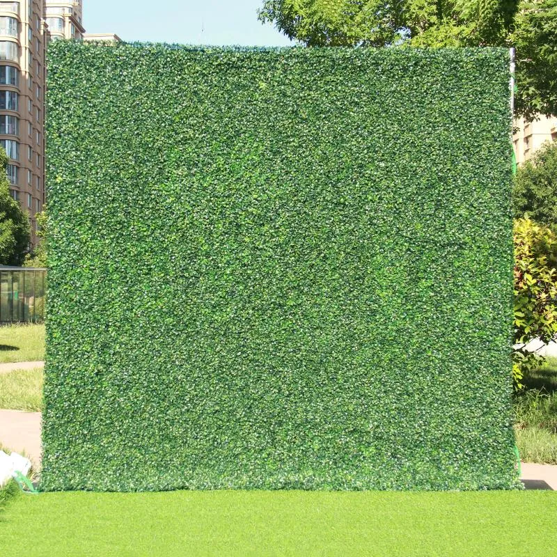 装飾的な花の布を裏打ちする緑の工夫草の生け垣の壁の背景とイベント退院