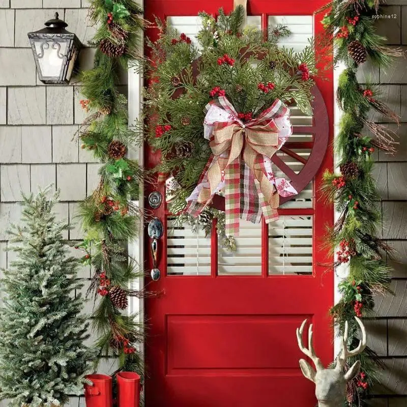 Decoratieve bloemen Kerstkransen feestkrans met rode bessen en dennenappelhuisdecoratie voor deurmuur