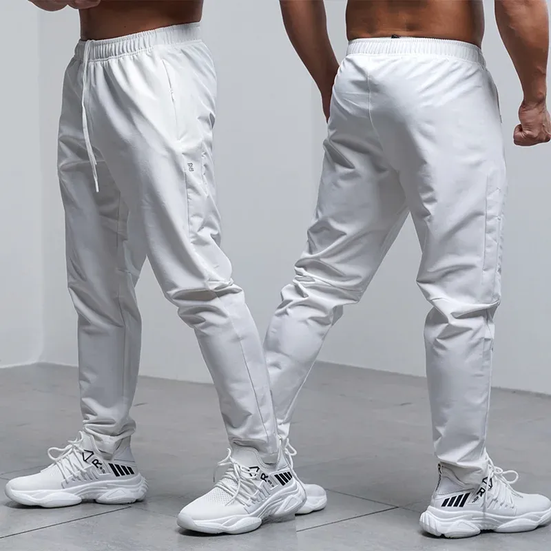 Calça calças respiráveis calças de corrida solta homens outono de inverno esporte ginásio esportivo elástico elástico à prova d'água de zíper de bolso de bolso de zíper ao ar livre