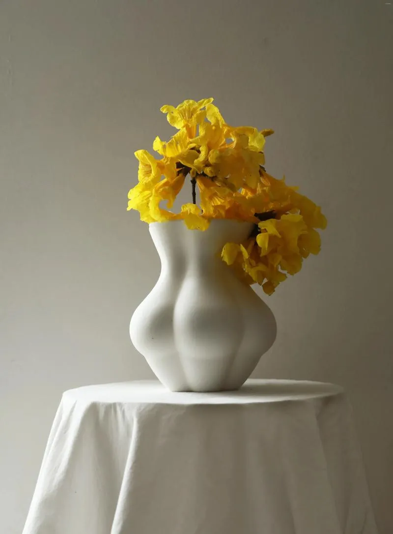 Vaser fyllda scallions ser bra ut kiki. Matt keramisk vas med midja och skinkor