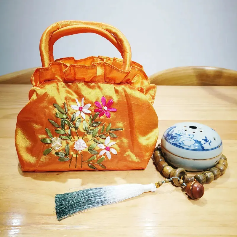 Oosterse esthetiek Oranje make -uptas Chinese traditionele handgemaakte bloemlint borduurzak met handgreep Hanfu Accessoires 240425