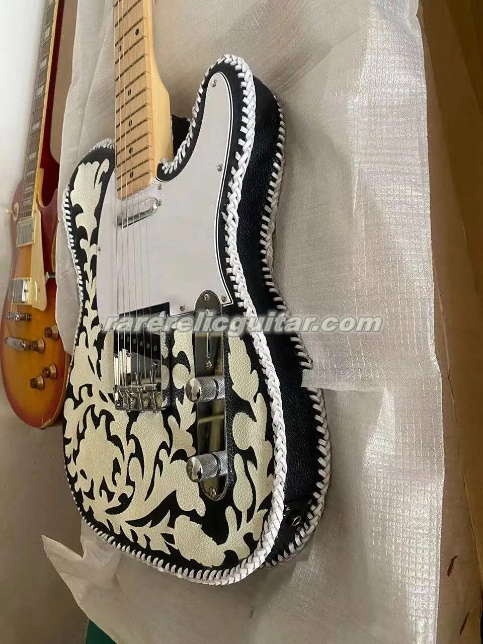 Disponibile Waylon Jennings Chitarra elettrica vintage in pelle lavorata in bianco e nero, tastiera con manico in acero, intarsio a punti, copertura del corpo intagliata a mano e rilegata in pelle.